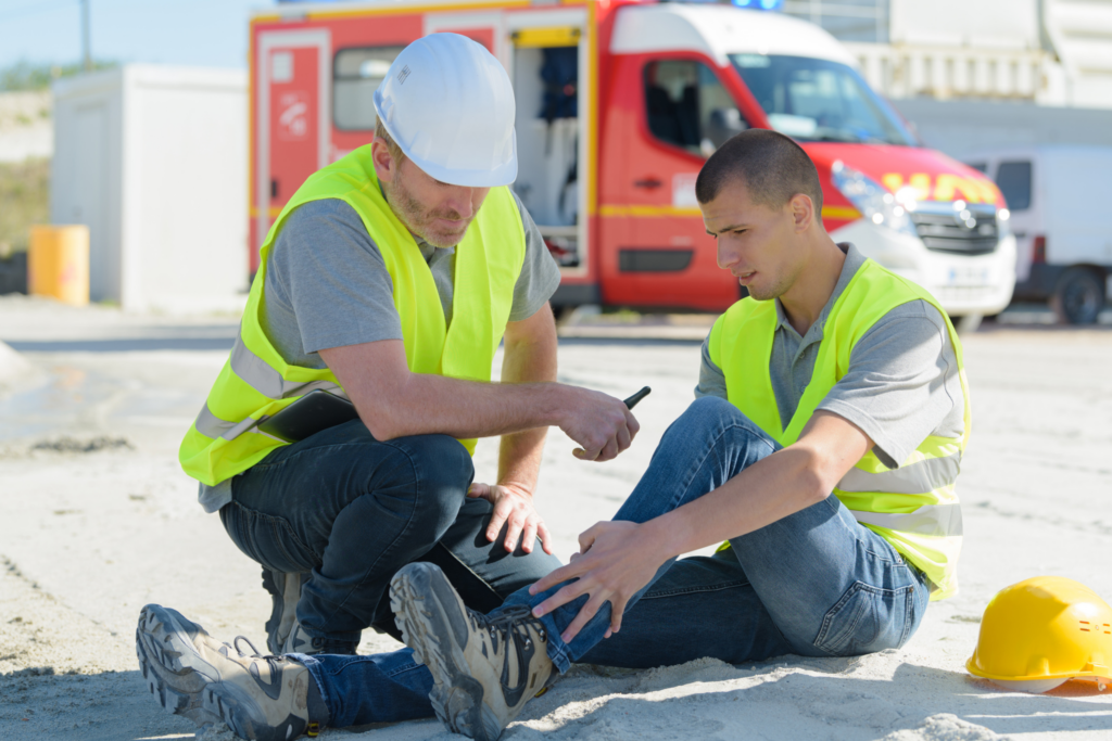 worker laying on ground holding leg after falling